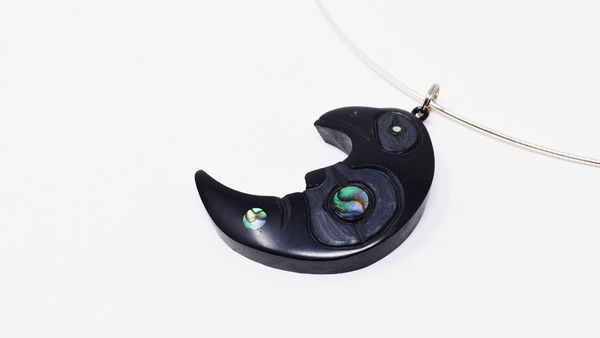 Raven in crescent moon pendant made wit argillite and abalone shell.