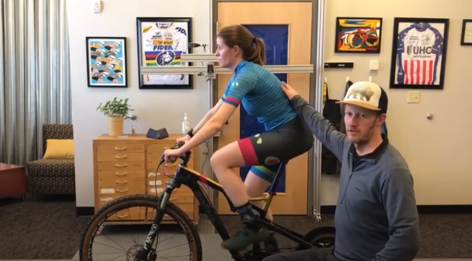 female cyclist demonstrates under-rotation of the hips on the bike.