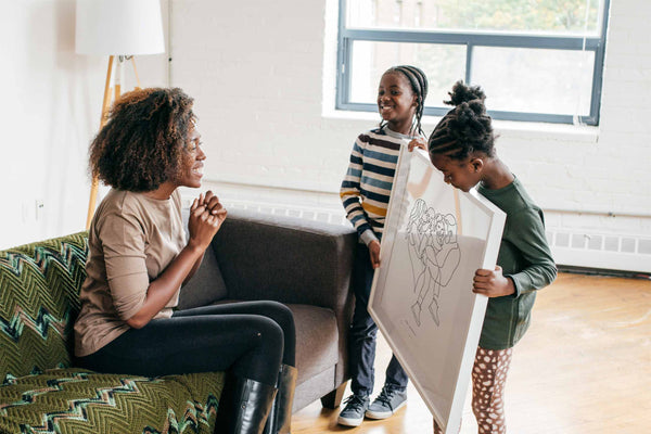 Hijas dando un regalo significativo a mamá, un dibujo familiar personalizado