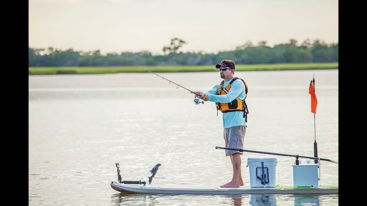 man with fishing gear on a paddle board