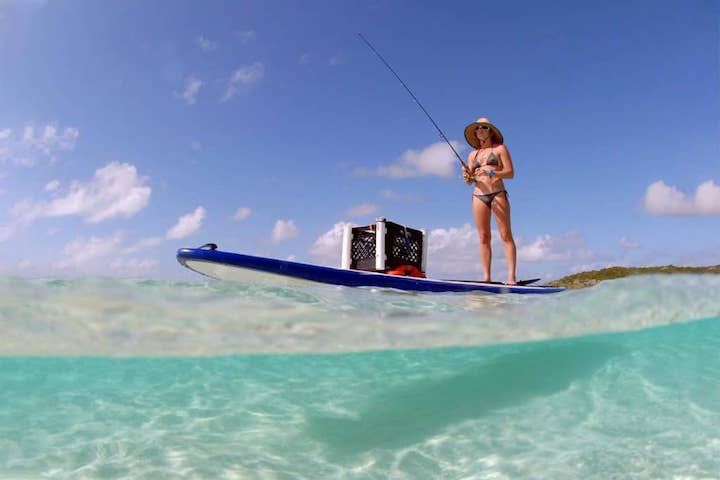 woman paddle boarding with a box on her paddle board
