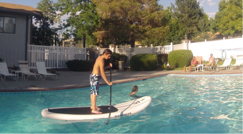 kid on a paddle board in a pool