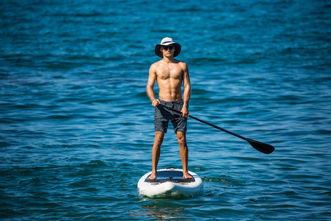 man standing on a paddle board in the water