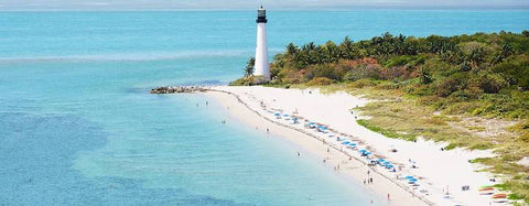 beach shoreline with a lighthouse in the background