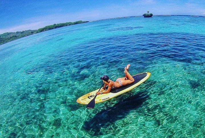 woman laying on a Tower wood paddle board