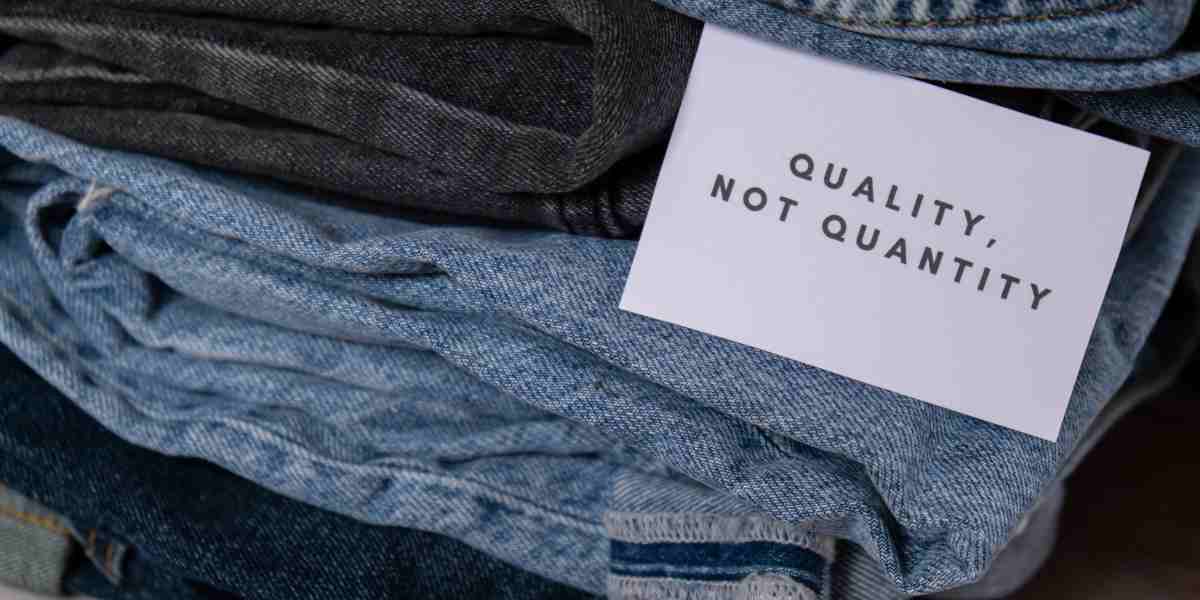 Pile of folded jeans with a 'Quality, not quantity' message, advocating for sustainable fashion