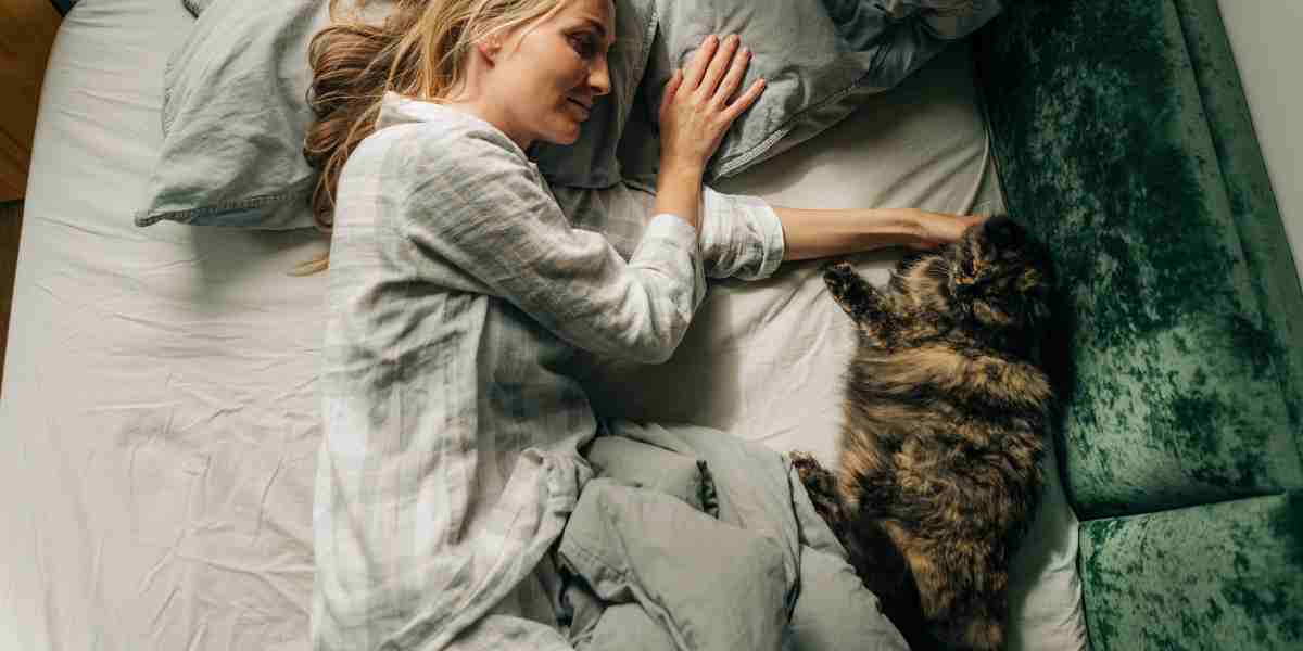 Woman enjoying a serene morning petting her cat in bed, symbolizing a peaceful start to the day.