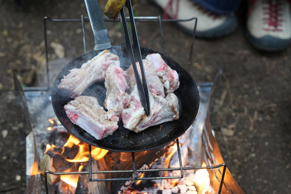 スペアリブを焚き火を使って焼いている様子