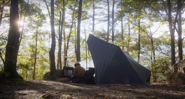 林間のキャンプ場でキャンプを楽しむ男性