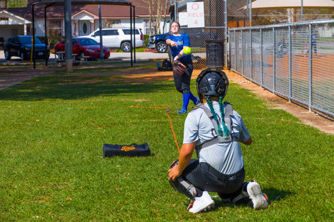 A softball pitcher using the Pitchers Alley product and pitching to their catcher.