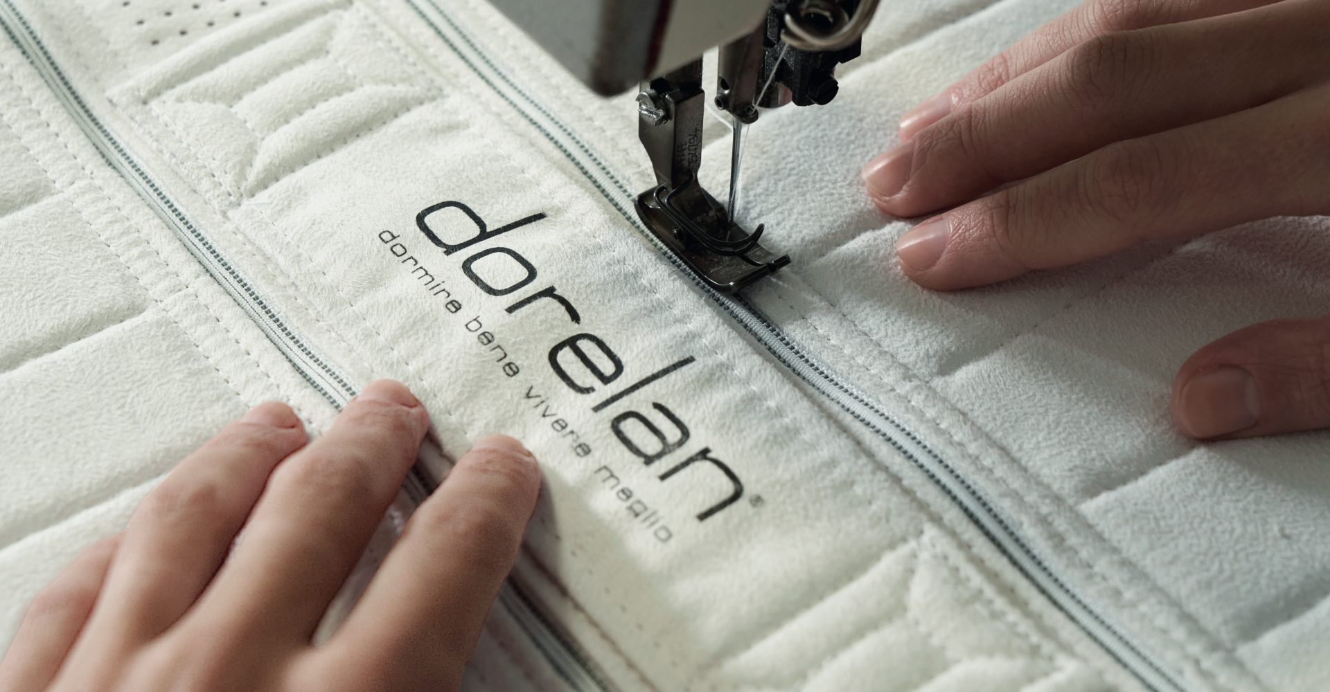 sewing Dorelan label on to mattress bed