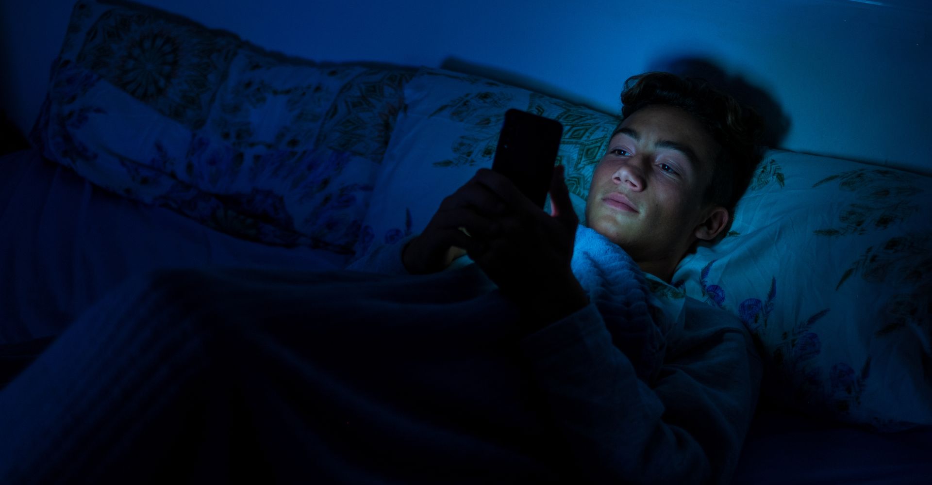 man looking at his phone in bed