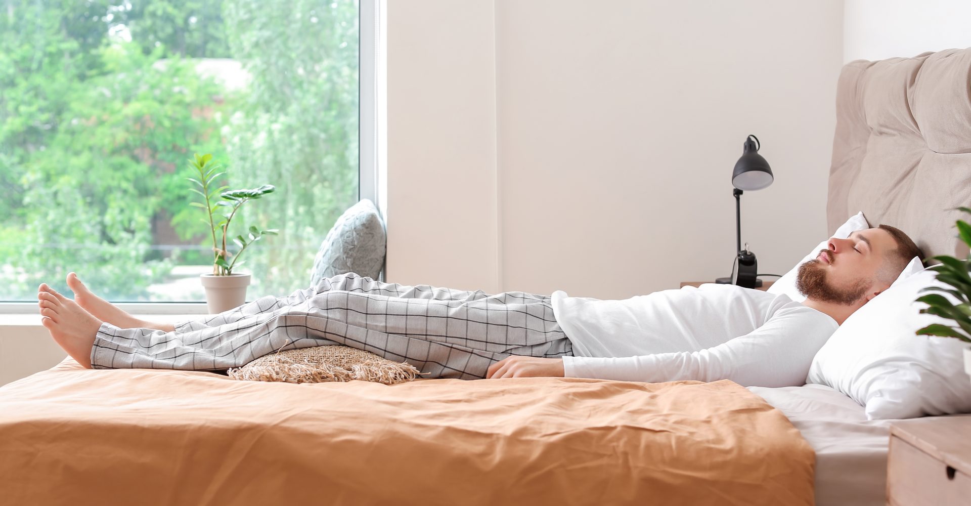 Side view of man lying on his back on bed