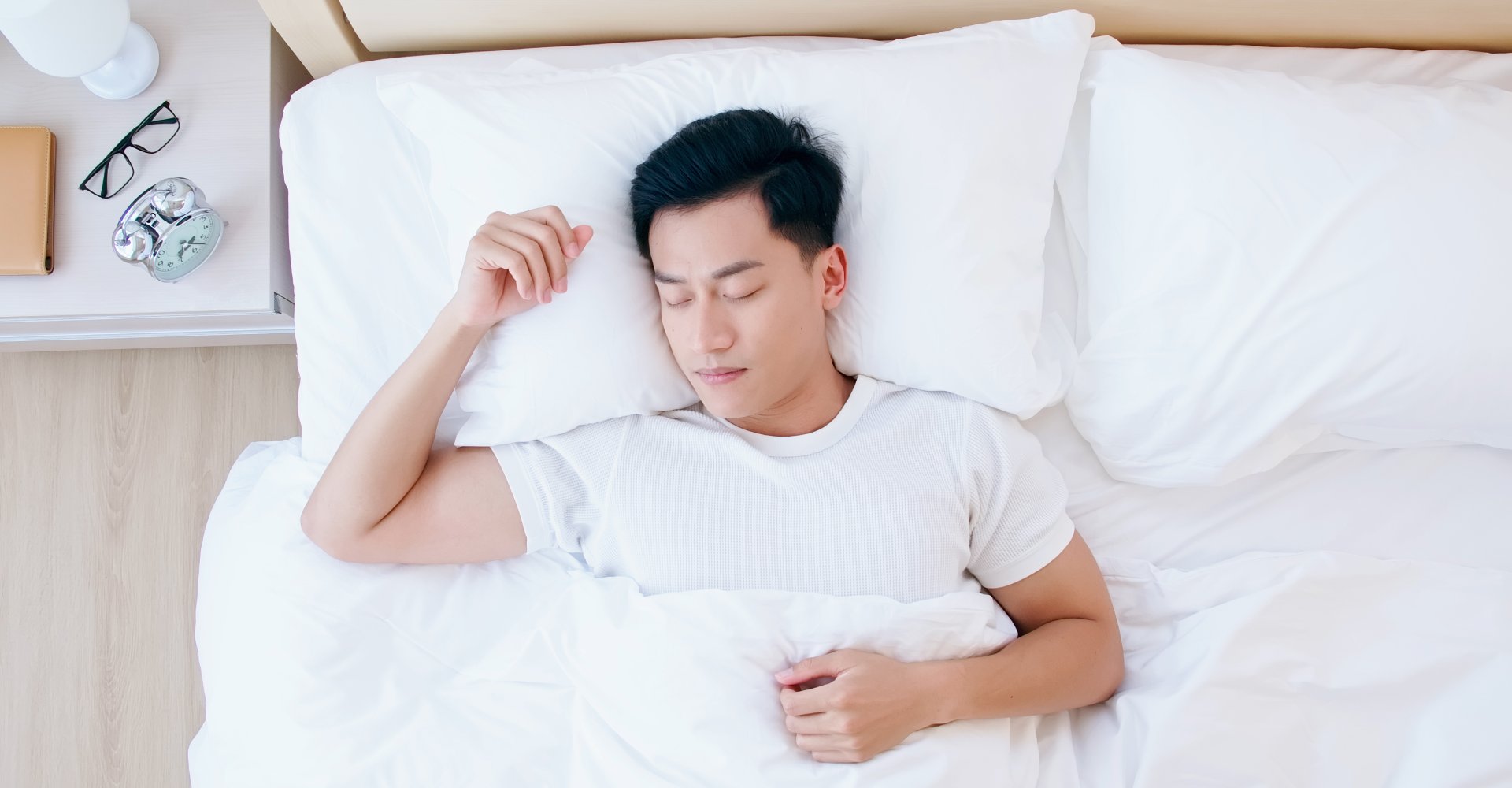 Man lying in bed with head on pillow