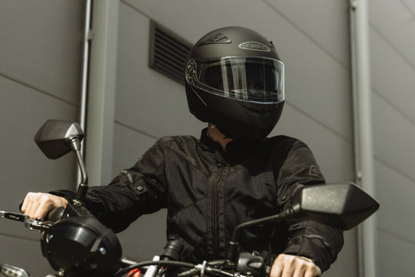 Mężczyzna siedzący na motocyklu w kasku 