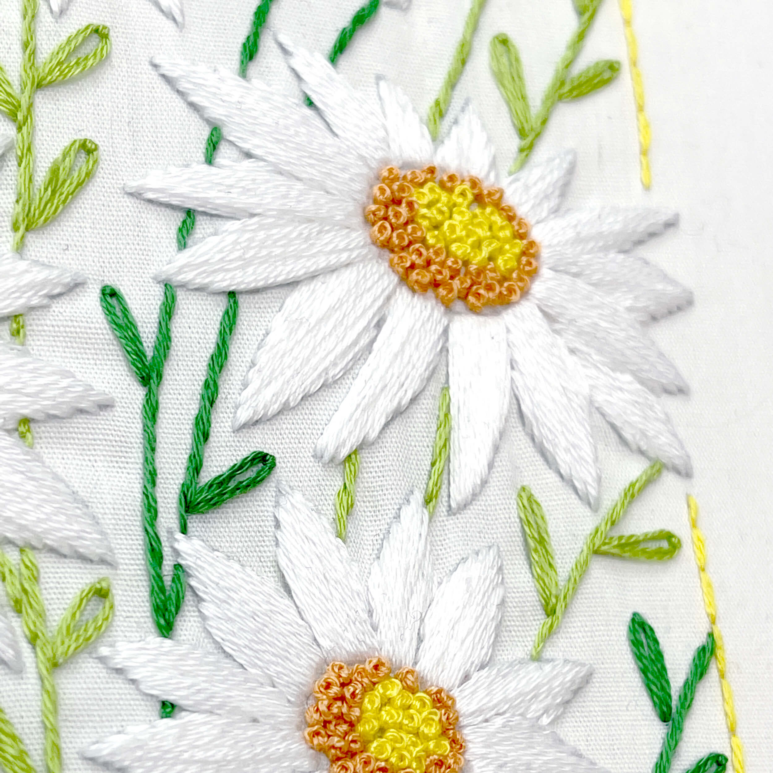 close up of satin stitch daisies