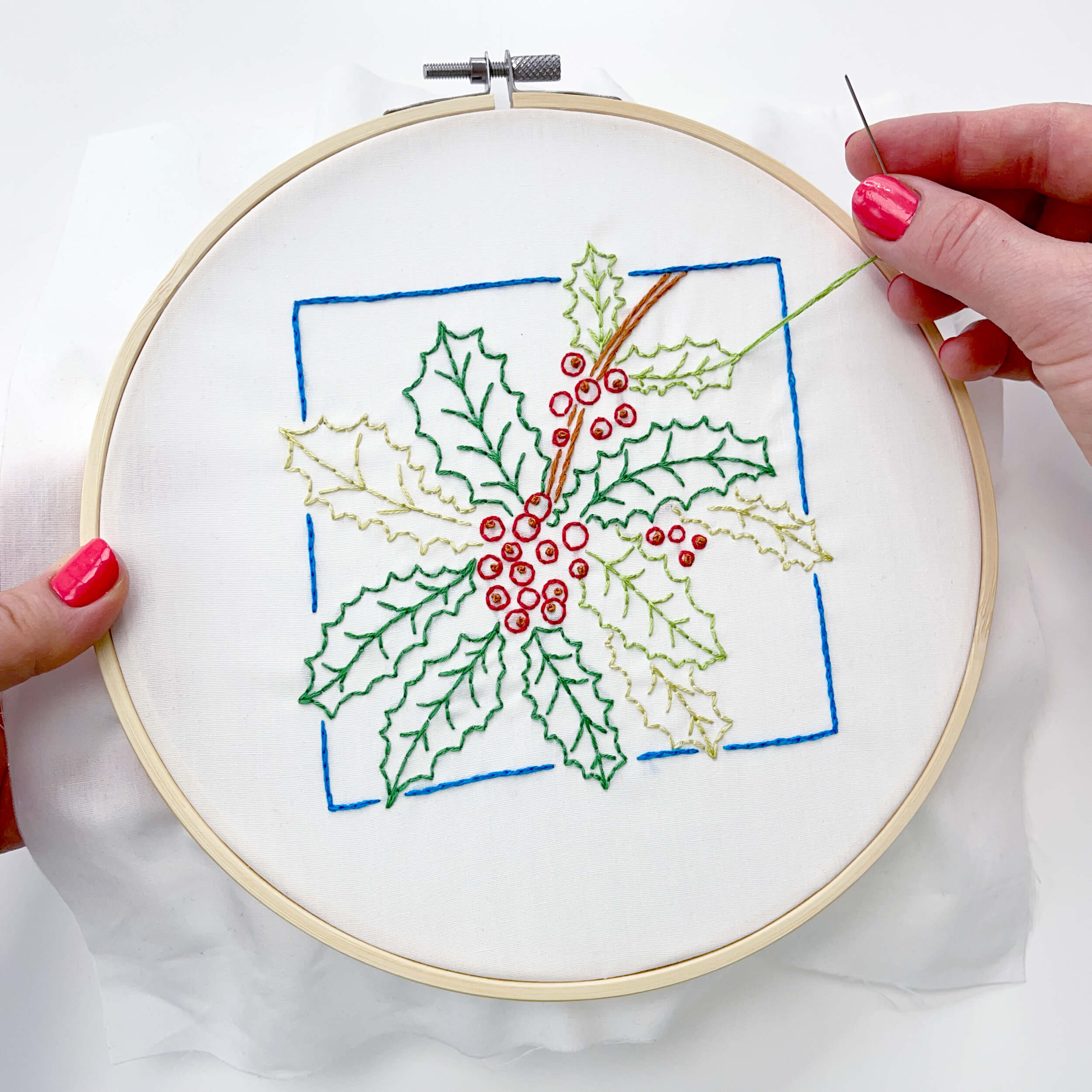 Hand stitching the green leaf in the Holly embroidery pattern