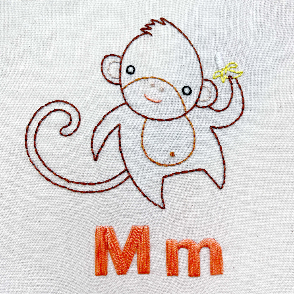 hand embroidered monkey holding a banana