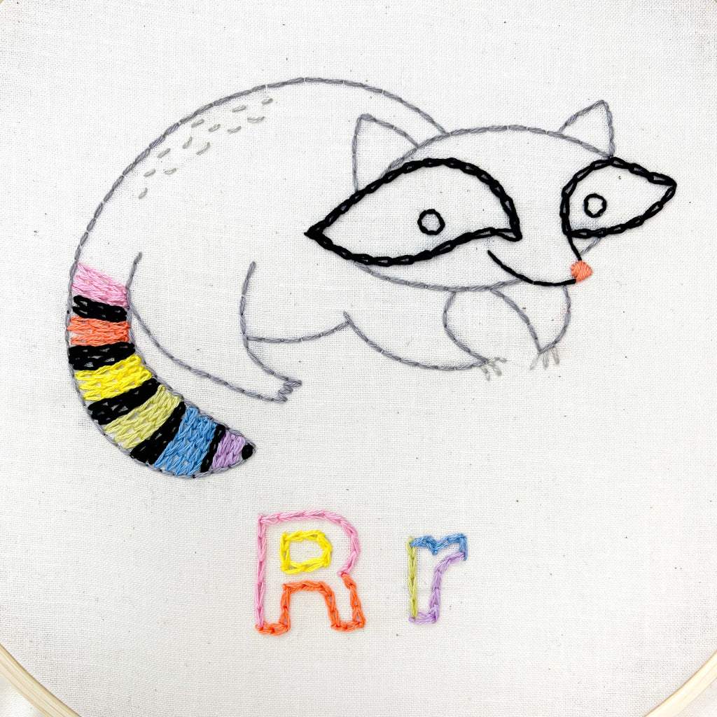 Hand embroidered raccoon with a rainbow tail