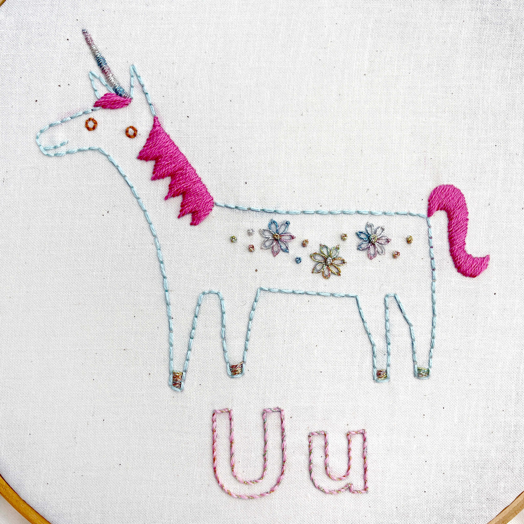 Unicorn embroidered with metallic thread for the horn and flowers on its back