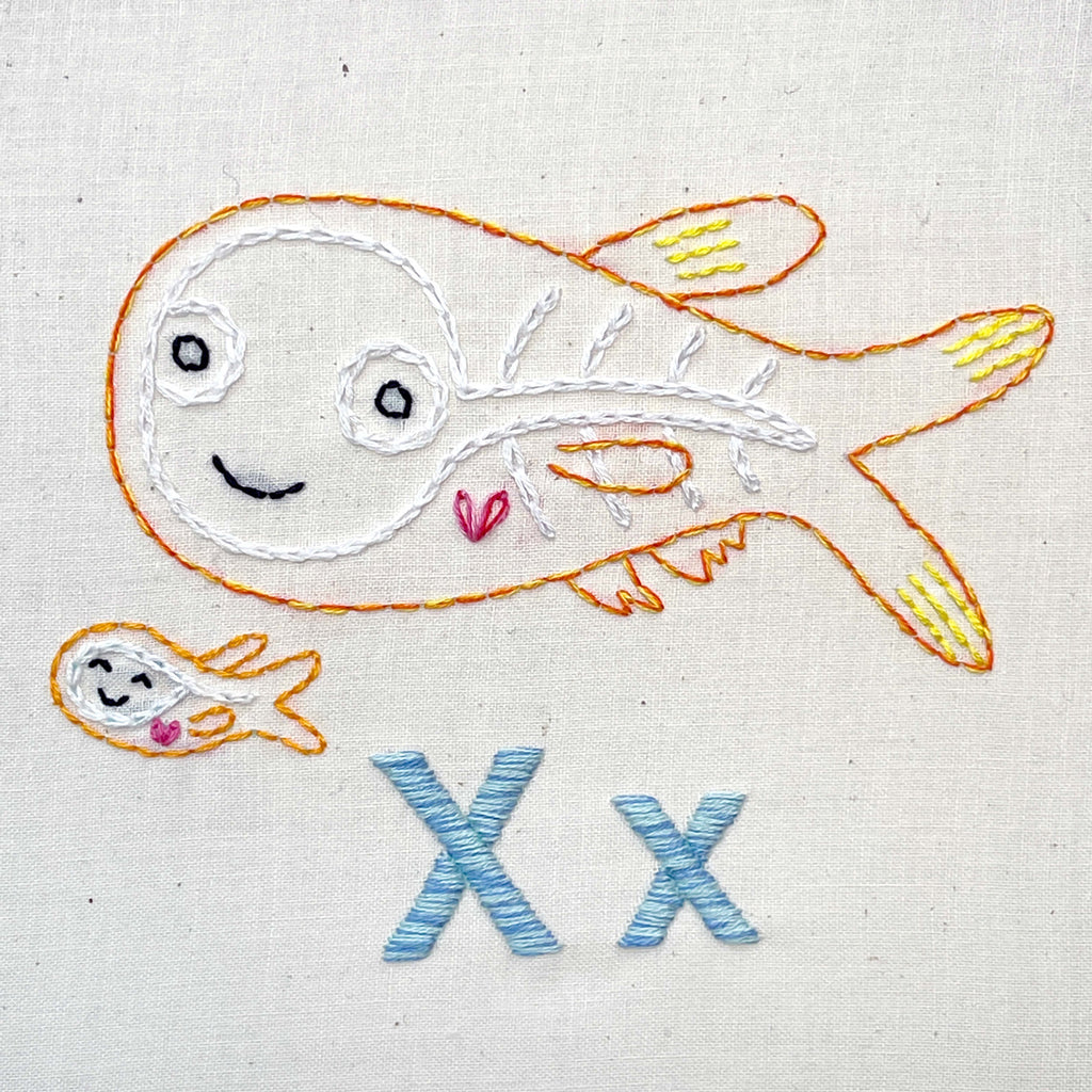 Xray fish hand embroidered with small baby fish underneath and the letters Xx stitched in blue