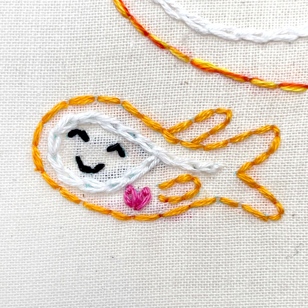 Close up of embroidered baby fish under bigger fish.
