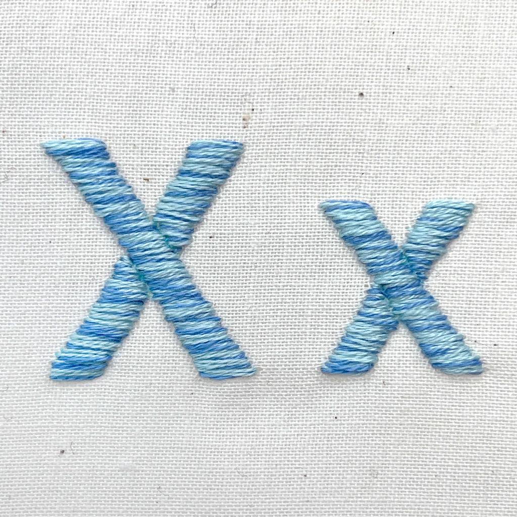 Letters X x stitched in a mix of blues