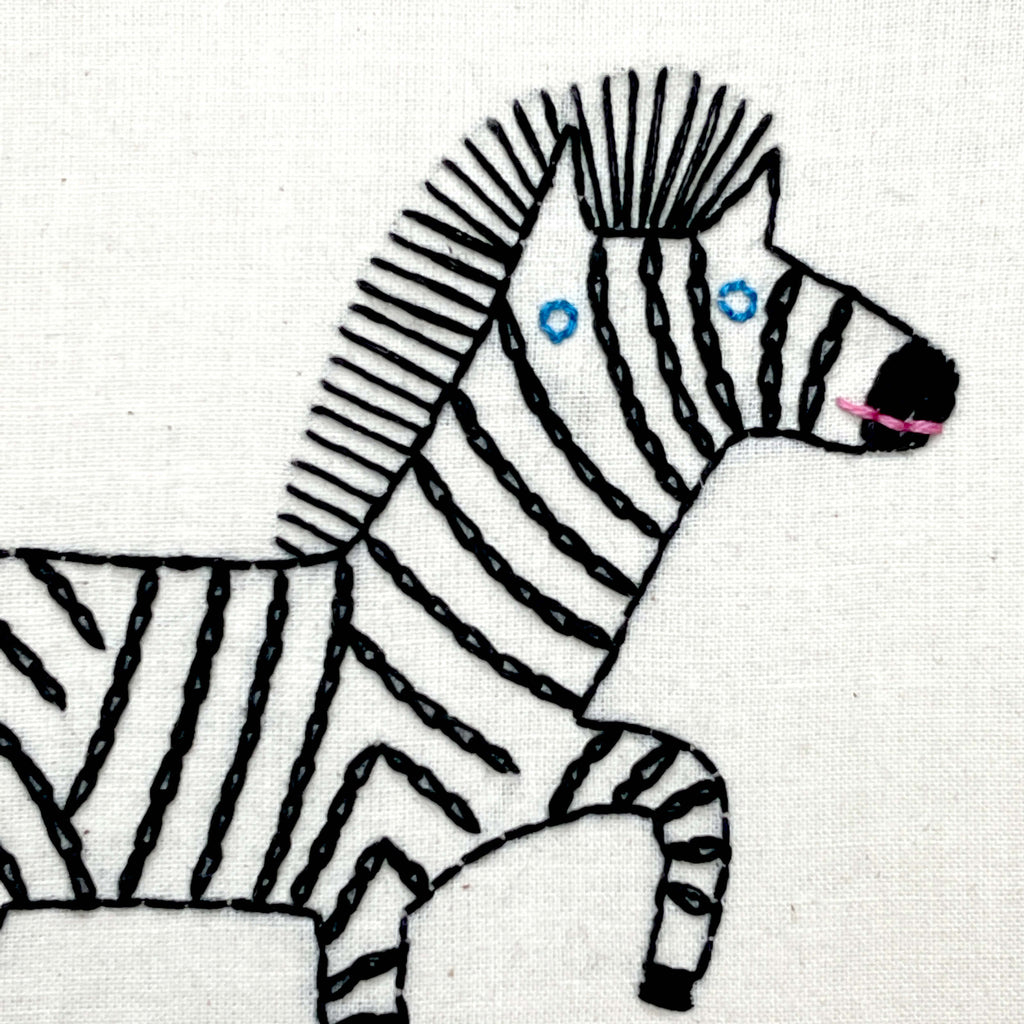 Close up of zebra with chain stitch stripes and blue eyes