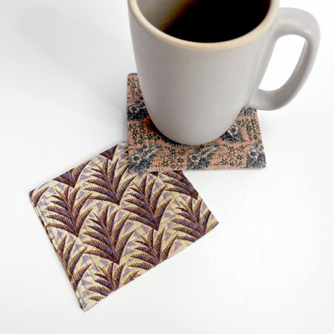 Fabric coasters with coffee cup sitting on one in beige colors