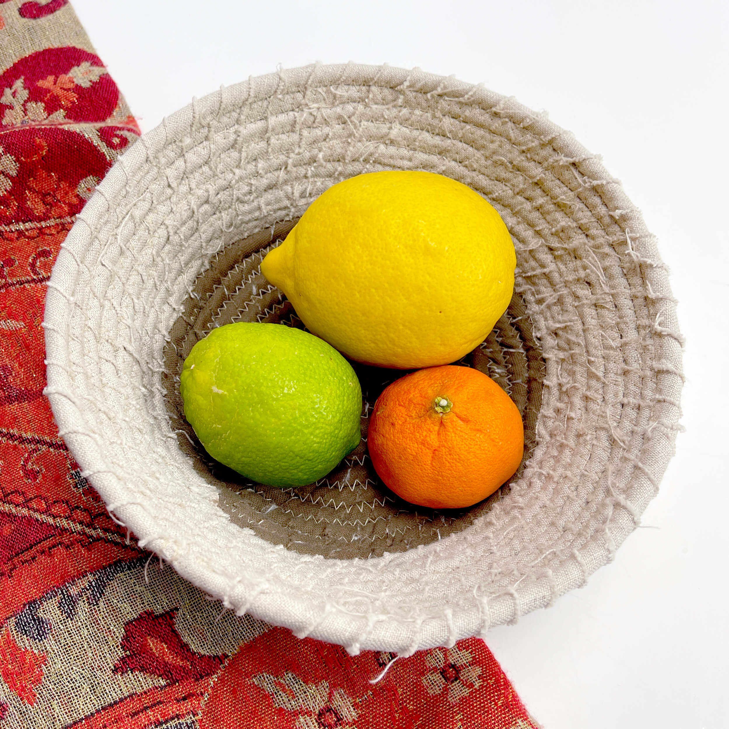 Cream colored fabric bowl with citrus fruits inside