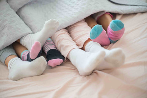 Die ganze Familie im Van unter einer Decke, nur die Füße sichtbar