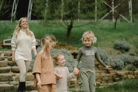 Drei Kinder mit ihrer Mutter draußen unterwegs