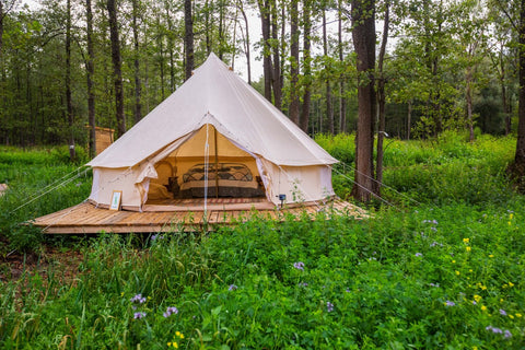 Glamping tent on a meadow with trees in the background