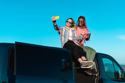 Duas mulheres tiram uma selfie no tejadilho de uma campervan