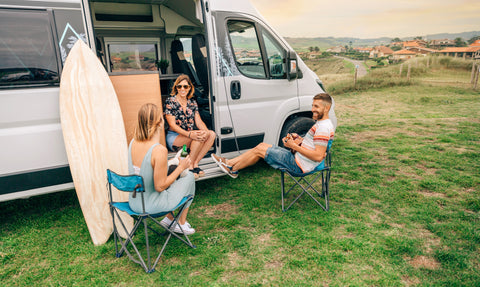 Three friends enjoy time with camper