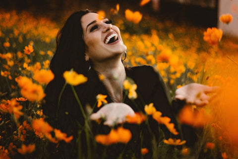 A mulher está feliz com o seu prado de flores no seu próprio jardim de loteamento. 