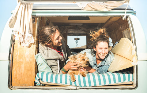 Casal feliz com cão em autocaravana