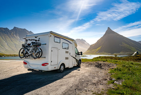 Autocaravana com bicicletas estacionada nas montanhas 