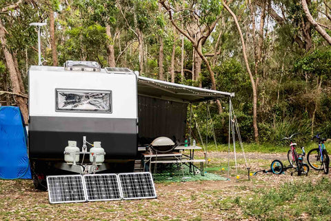 Wohnwagen auf Campingplatz im Wald mit Solar Panel.