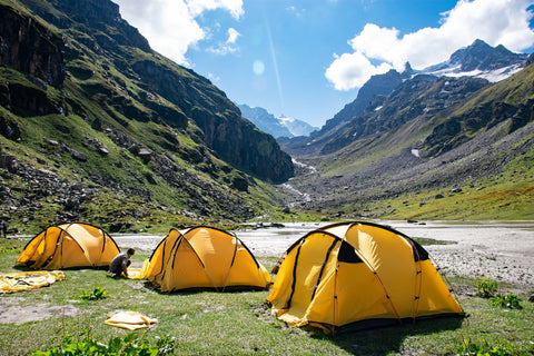 Three yellow tents in the mountains