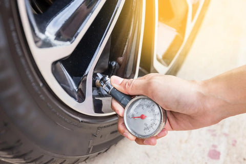 a man checking car tire pressure