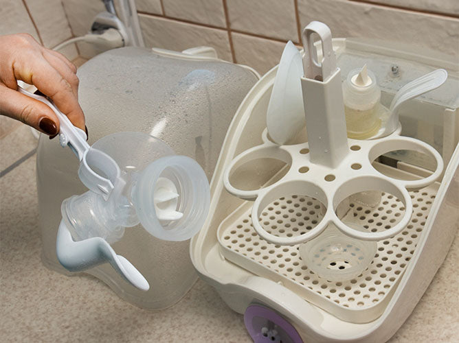 Breast pump parts being cleaned in a microwavable sterilizer.