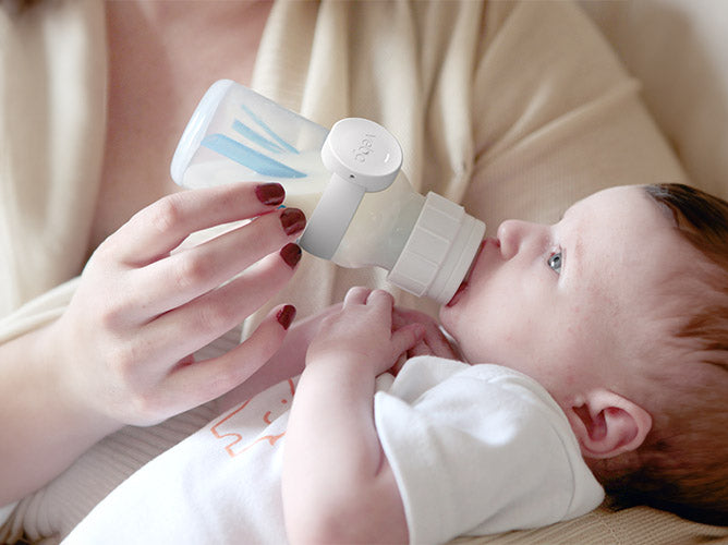 Veba smart bottle monitor, wrapped around a baby bottle.