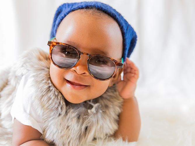 Cute, unique looking infant wearing sunglasses.