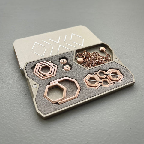 Hexagon silver jewelry with rose gold plating, in a small travel case the size of a credit card