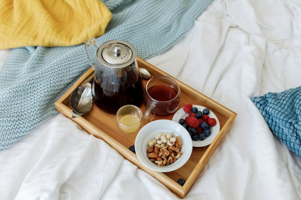 tray of a variety of healthy food on a bed
