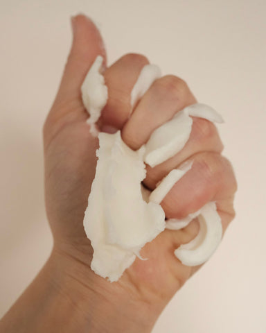 Shea butter being squeezed by a hand