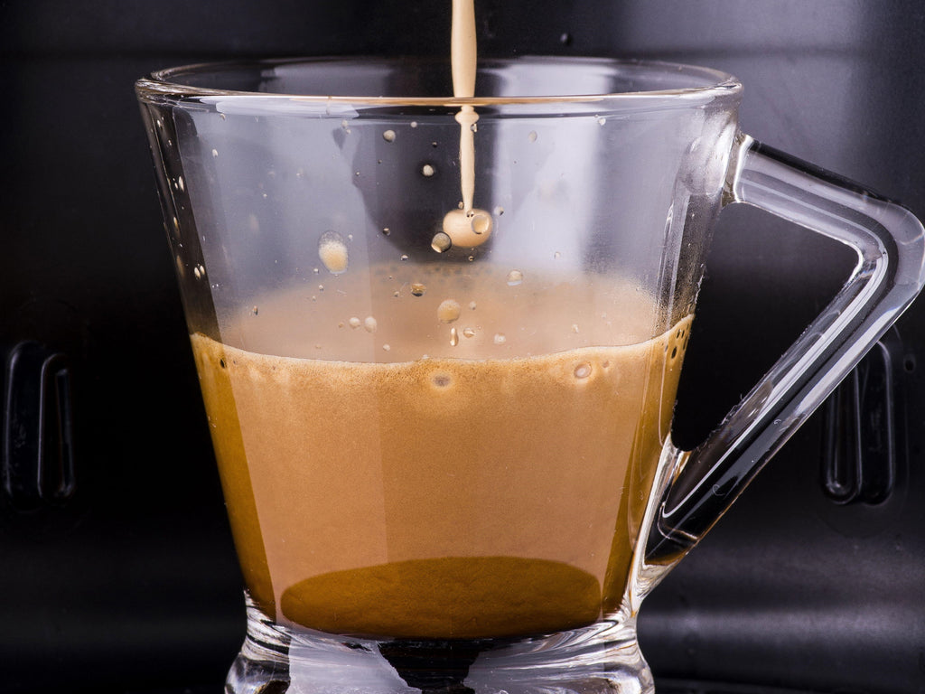 Wholesale coffee capsules being brewed into a transparent cup