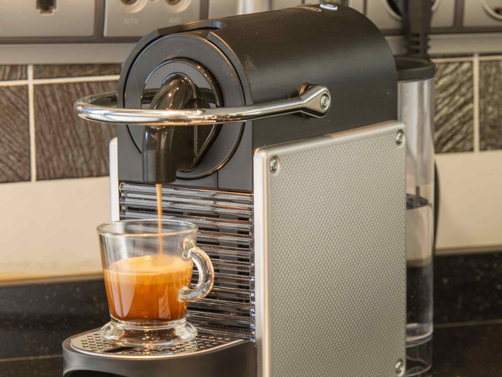 Brewing a wholesale coffee capsule using a Nespresso original line brewer.
