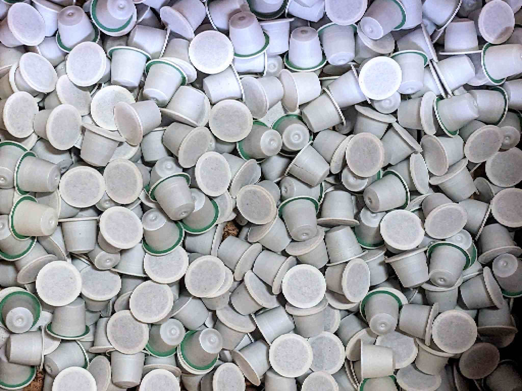 A pile of sealed coffee capsules